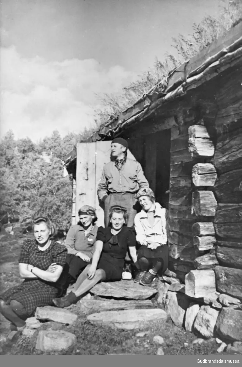 Fem personer samlet ute på trappa på Sy-Kvamssetra, Grøndalen, trær i bakgrunnen.

