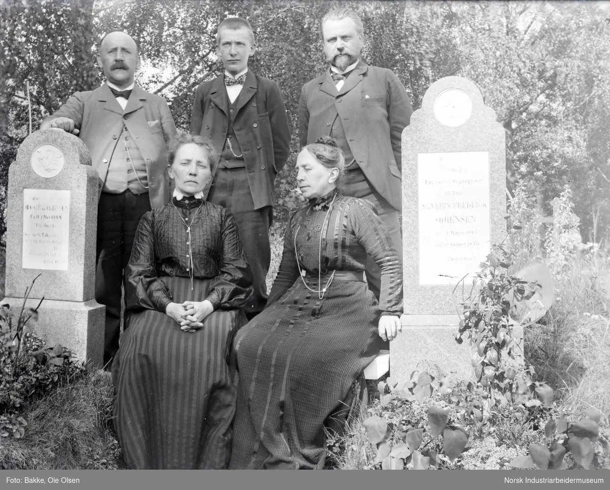 Familie sittende ved gravstein for Prost Severin F. Sørensens på Atrå Kirkegård.