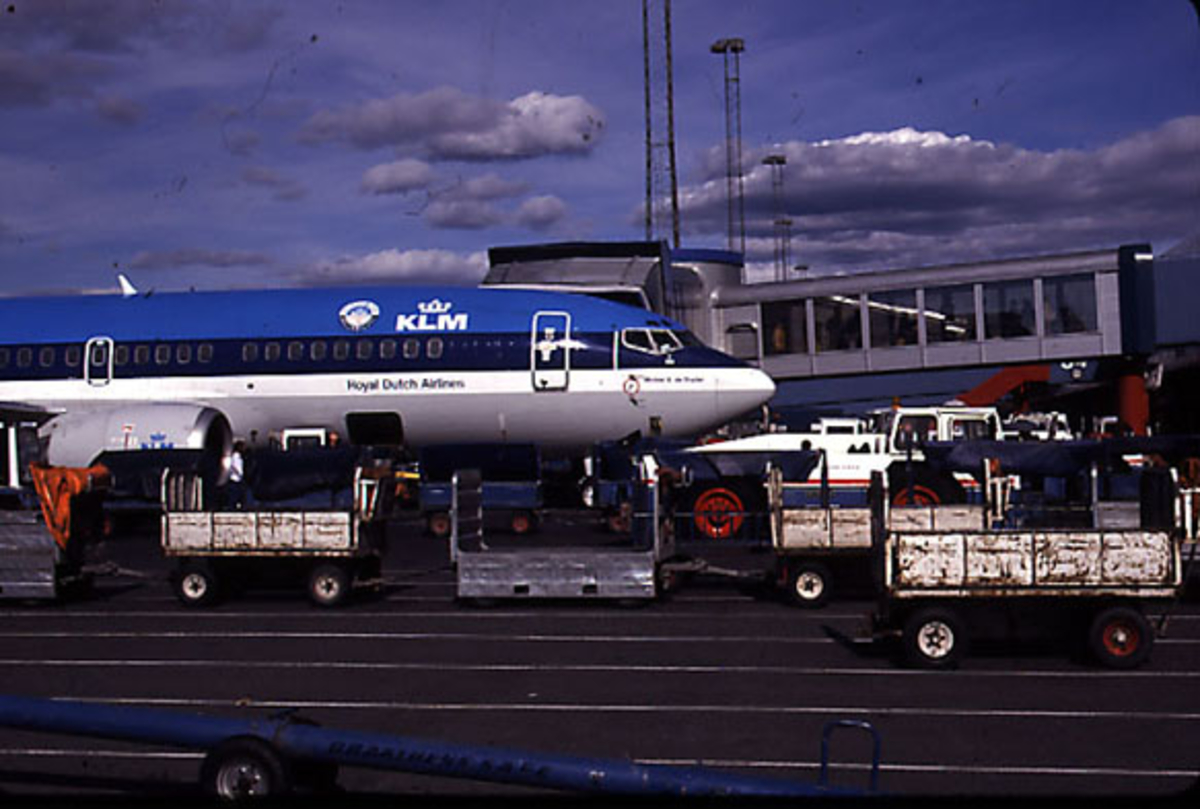 Lufthavn, 1 fly på bakken, Boeing 737-306, PH-BDG fra KLM, parkert ved landgangen - gaten - bagasjevogner ved flyet.
