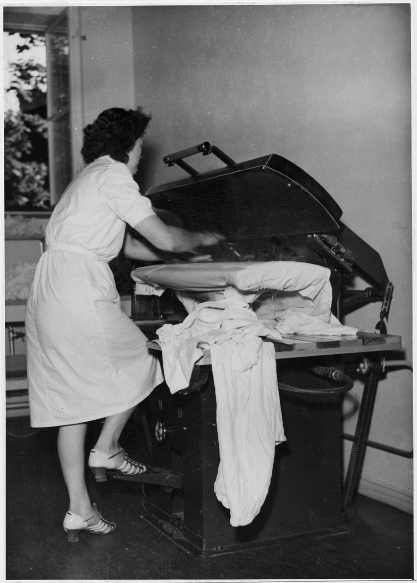 Tvättinrättning för arbetare, Fagersta bruk
Interiör med kvinna som pressar tvätt