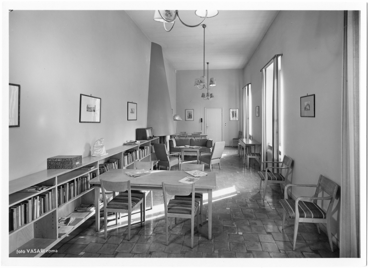 Svenska Institutet i Rom
Interiör. Möblerat rum med bord och stolar, bokhylla utmed vägg.