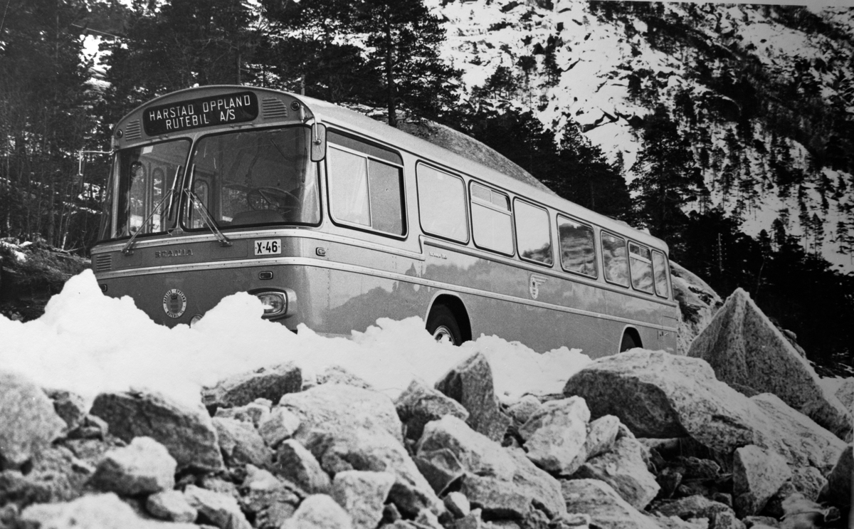 Buss X-46 fra HORB i vinterlandskap. Sprengstein i forgrunnen.