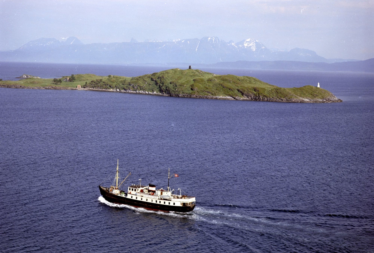 Flyfoto av lokalbåten m/s "Harstad" på tur fra Harstad, med Måga i bakgrunnen.