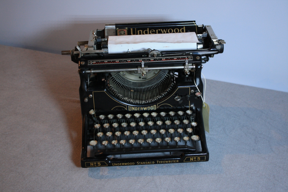 Underwood no5 skrivemaskin. Manglar bokstaven Å.  Firmanamn med logo på topp av maskin.