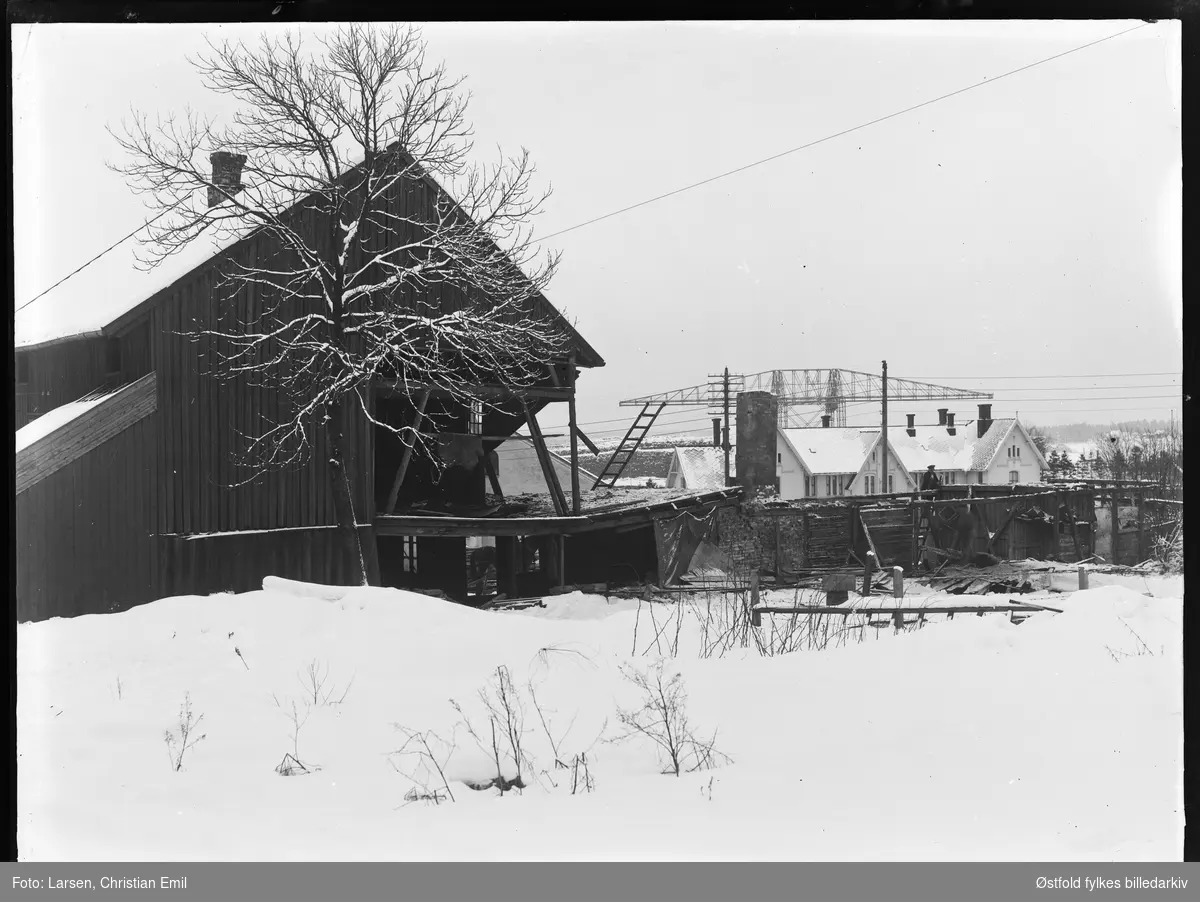 Riving av garveriet i Glengsgata 14 i Sarpsborg januar 1927.  Sarpsborg jernbanestasjon og tømmerkrana på Opsund i bakgrunnen.