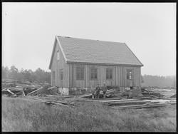 Gammelt trehus med tre barn utenfor. landlig plankerester ru