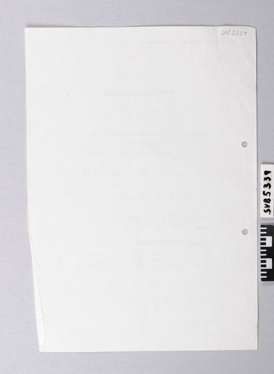 Papir ark med  trykt og håndskreven tekst på den ene siden.