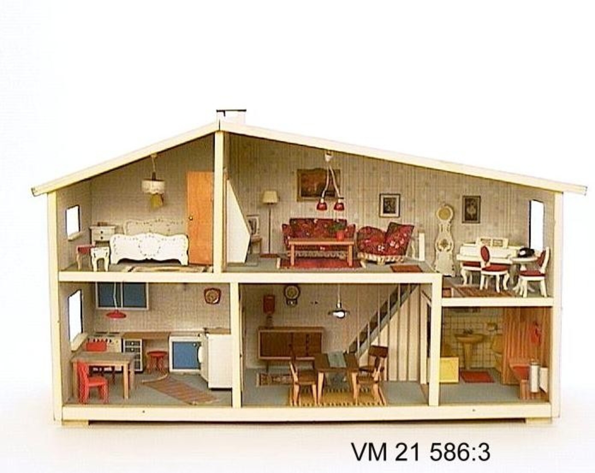 Dockskåp med rödbrun fasad, av samma modell som 21 586:1. Detta hus har dock skorsten.

Övre hall och sovrum möblerat i rococostil, Övriga möbler i 1960-talsstil.
