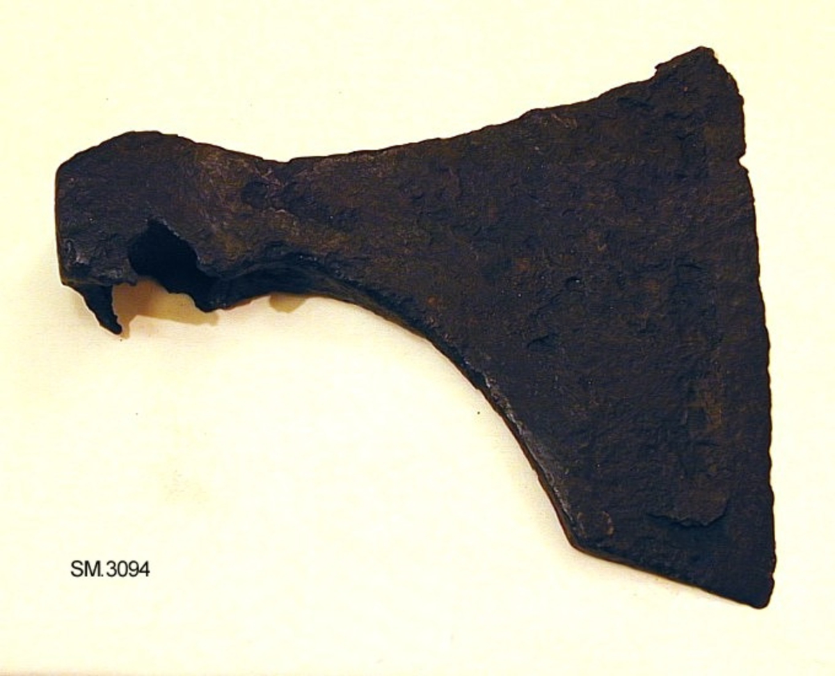 Øks av jern, av form som Jan Petersen, type D, Vikingesverd, fig. 31, dog synes skaftflikene å ha vært lite utviklet, men butte, ellers skiller vårt eksemplar seg lite fra typen. Noe forrustet.   Hammerens størrelse 3 x 3,5 cm. Ingen funnopplysninger. Datering: første halvdel av 9. årh. 