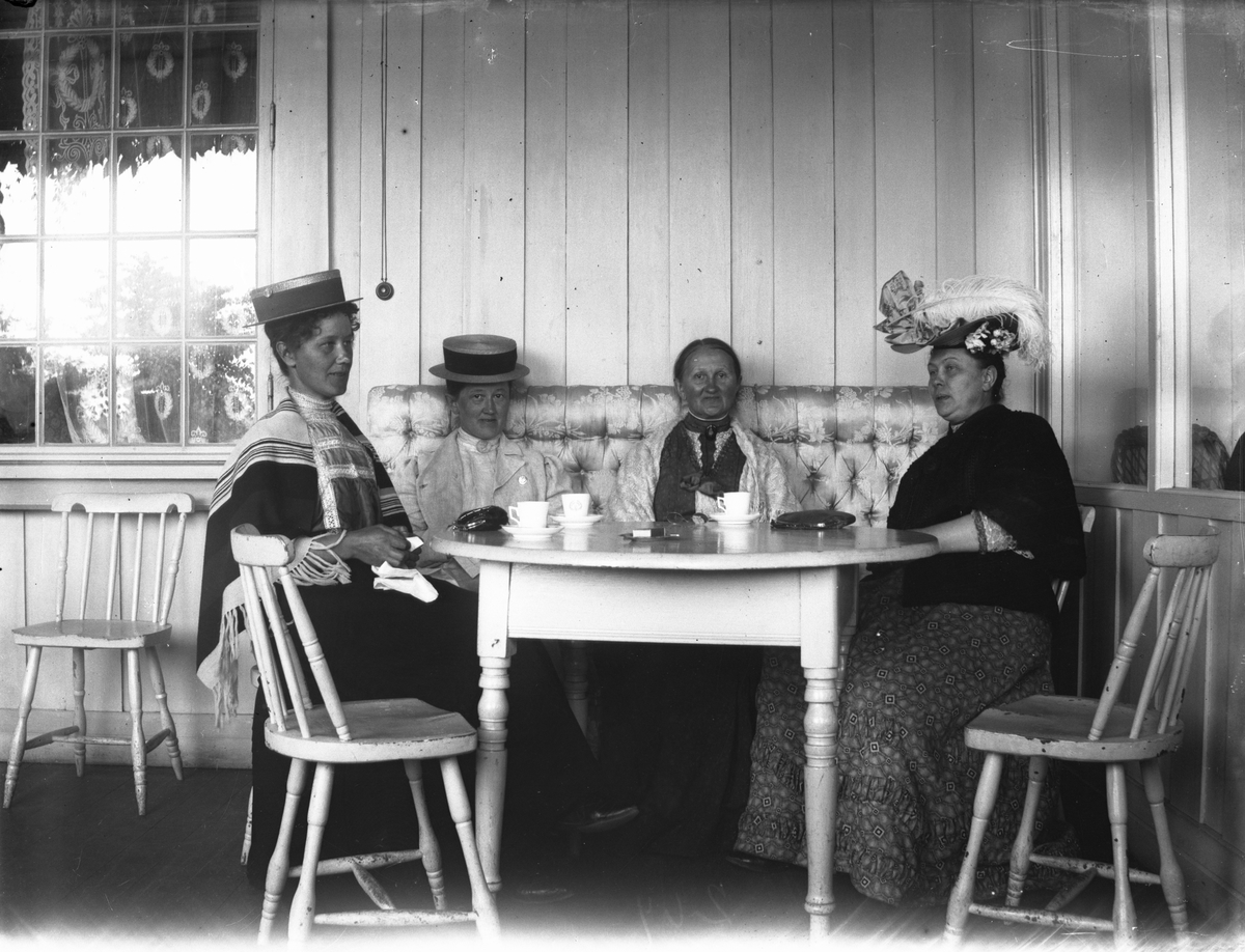 Fire damer rundt bord på veranda