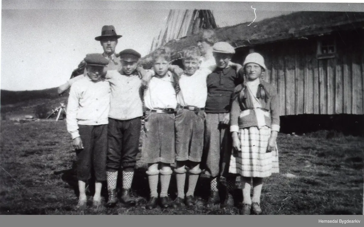 På Lykkjastølane i Hemsedal ein gong på 1930-talet.
Frå venstre: Embrik og Torleif Veslestølen, to bygutar, Haldor og Gladys Veslestølen.
Bak: byfolk.