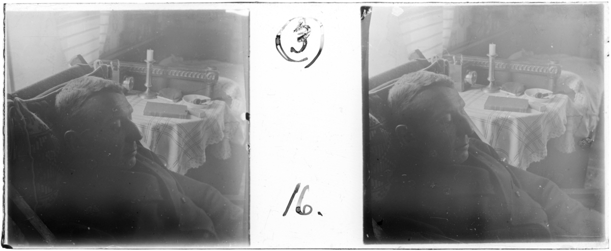 'Bildtext: ''M. L. i en vilstol.'' :: Närbild, ansiktsbild, på Magnus Leijer sittande i vilstol. Interiör med soffa och bord med pipa på ett fat, bok, ev. kamera, ljusstake, portmonä och duk. Möbler. ::  :: Ingår i serie med fotonr. 5252:1-17, se även hela serien med fotonr. 5237-5267.'