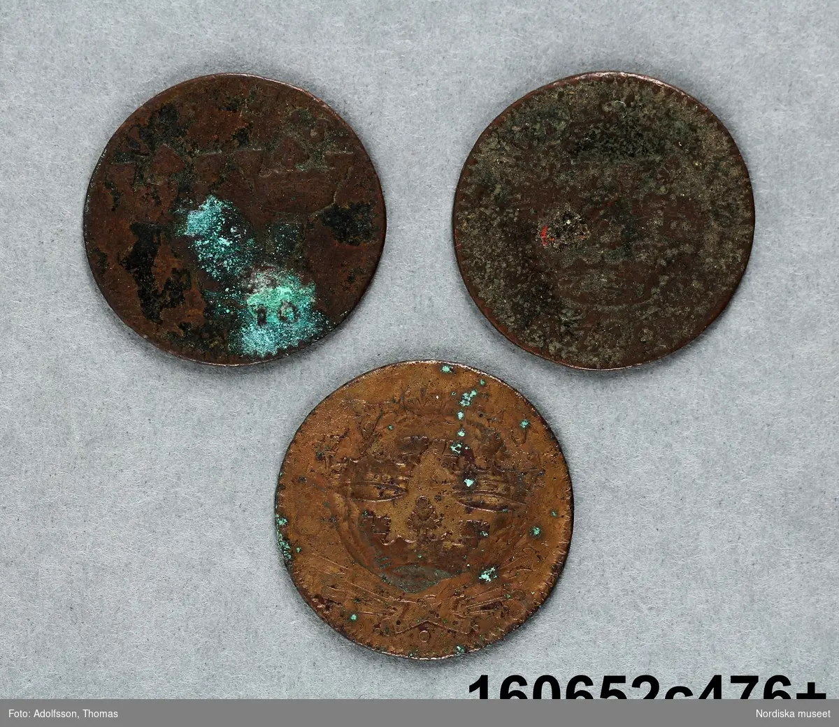 Tre mynt med oläsliga årtal.