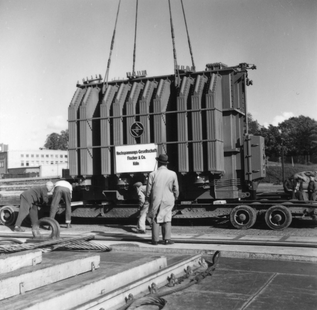 Transport av transformator 50 kW. Lastning i Göteborgs hamn, 17/6-1955.
Några män är med på bilden.