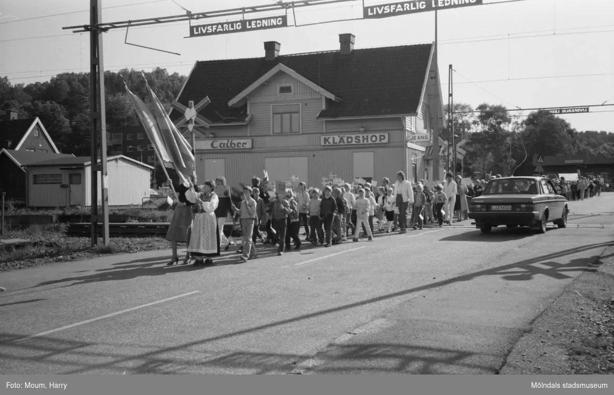Nationaldagsfirande i Kållered, år 1983. Festtåg vid järnvägsövergången på Labackavägen.

För mer information om bilden se under tilläggsinformation.