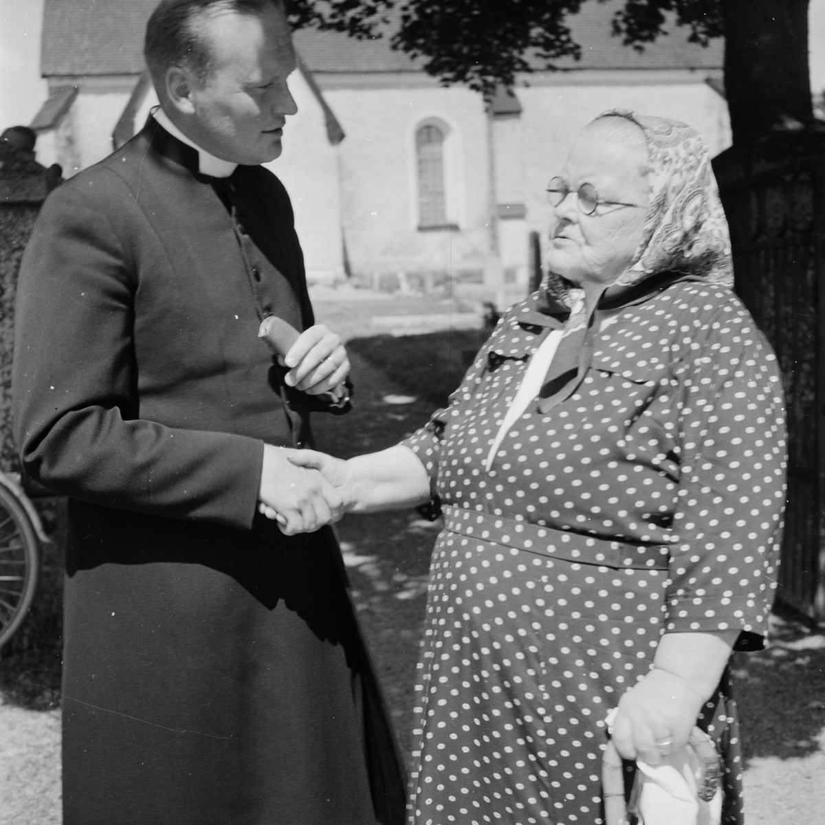 Präst skakar hand med kvinna, Holm socken, Uppland