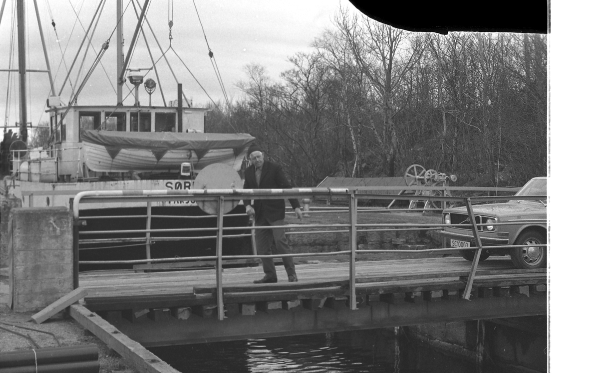 Slusene i Skjoldastraumen. Operatør i arbeid med å åpne og stenge slusene. Biltrafikken har stoppet opp i påvente av at fiskebåten "Sørbu" fra Farsund skal passere.