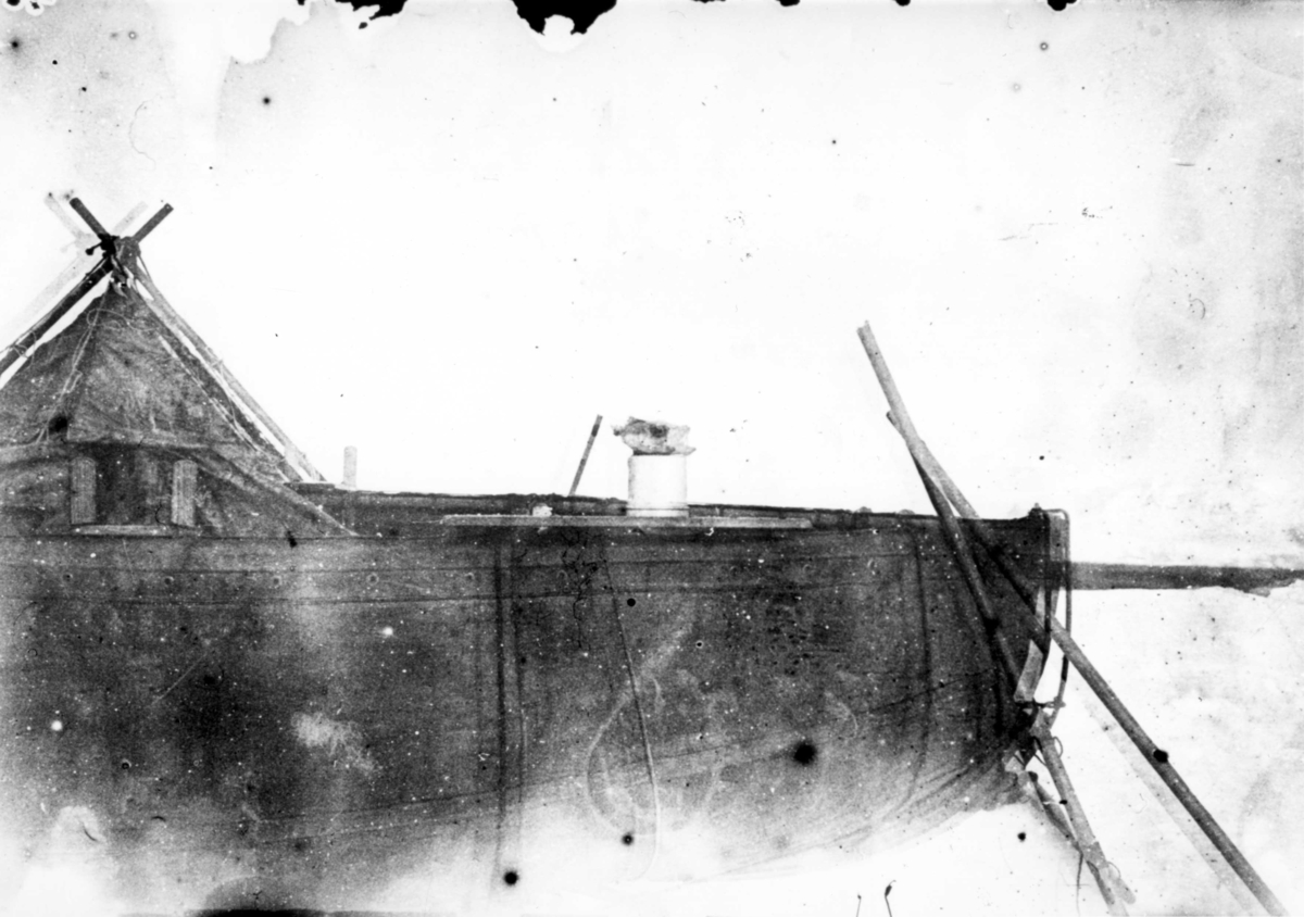 Oretuscherad. Isvandringen. Ett torskhuvud på båten. Åror lutade mot båten, tältet på andra sidan. Reprofotografi av gm.III-84.