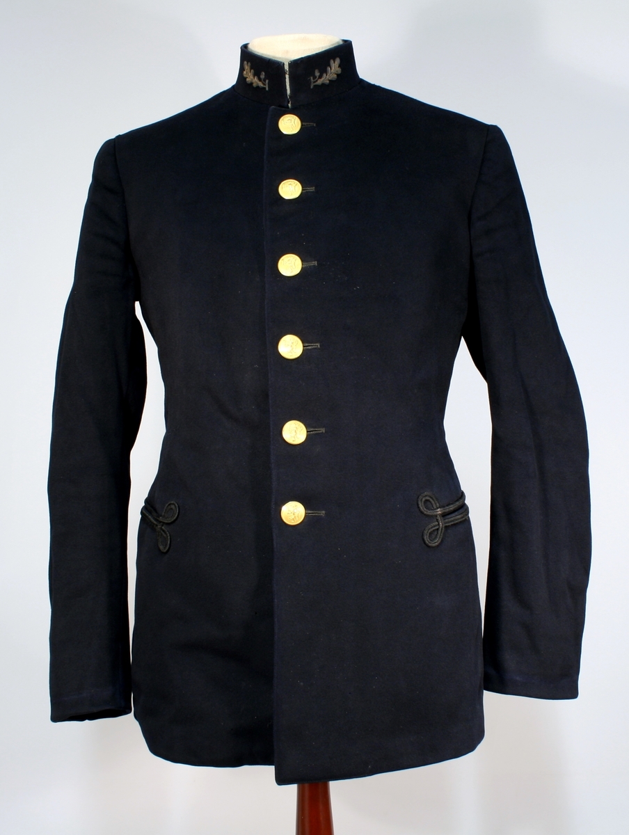 Mørkeblå uniformsjakke med seks forgylte knapper med riksløven. Oppstående krage med ekeblad på kragespeil og to sidelommer med snordekorasjon. Ingen skulderdistinksjon.