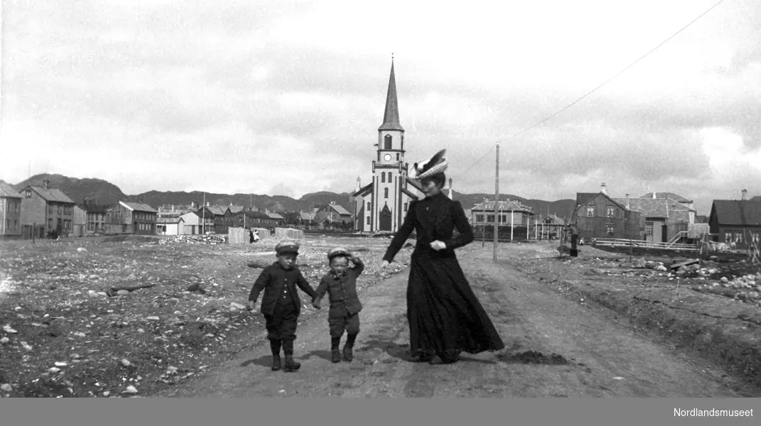 Kvinne med to barn i Prinsens gate, kirken i bakgrunnen.