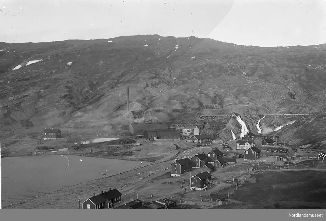 Fagermoen ved enden av Langvannet i Sulitjelma. Smelteverket i midten på bildet. Kraftstasjonen og vaskeriet til høyre for smelteverket. Elven midt på bildet er Fagerli. En rekke bolighus til høyre. Fra bildets venstre kant ses en taubane.