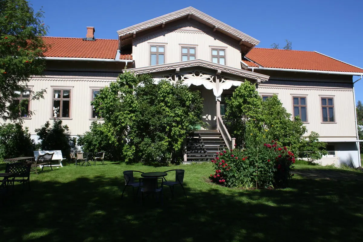Kvinnemuseet med blomsterbed og sveitserstilveranda