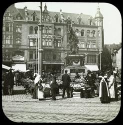 En gruppe mennesker på et frukttorg rundt en minnestøtte