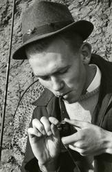 En fluefiskere tenner sin pipe.