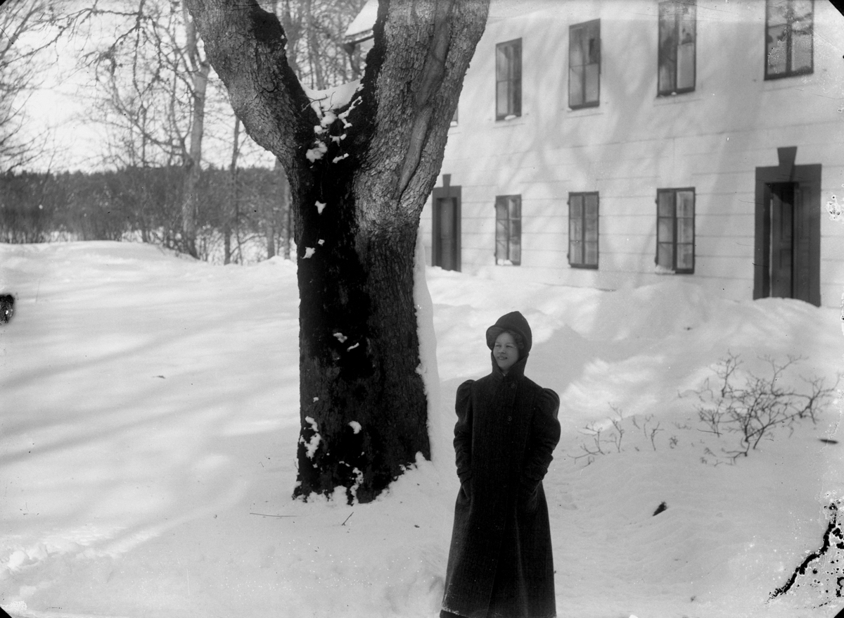 En ung kvinna, bostadshus.
Vinterbild.