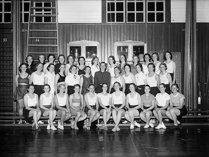 Interiör av gymnastiksal, gruppbild.
Arbetarnas Gymnastikförenings kvinnliga avdelning.
