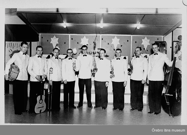 Orkester, nio män med musikinstrument.