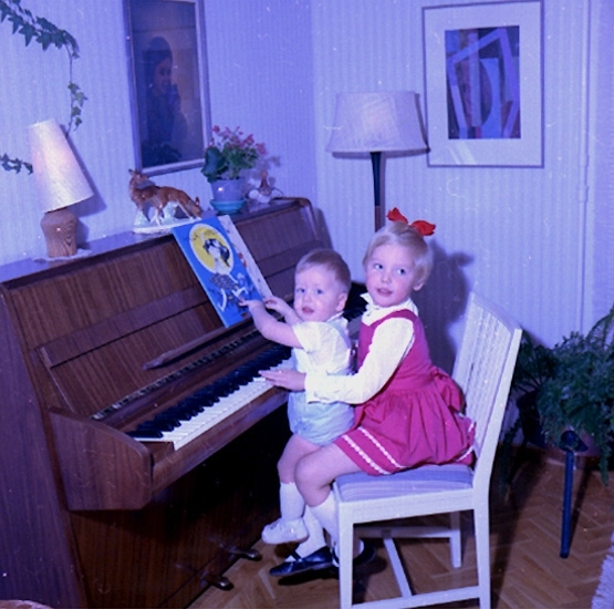 Rumsinteriör, två barn vid pianot.
Bertil Larsson