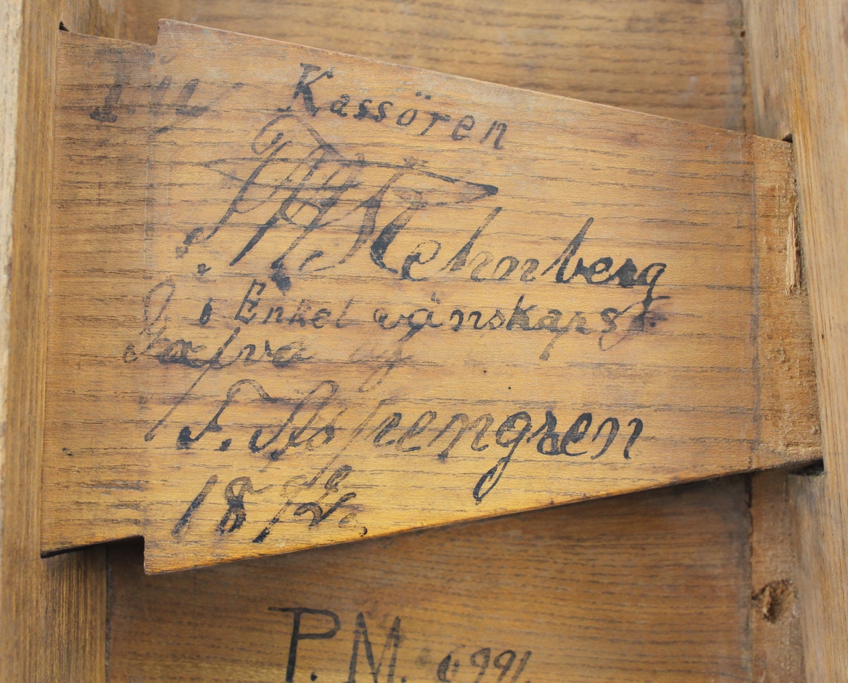 Mynträkningsplatta lutande med sarg. Undertill utdragbar låda med textil i botten. Avsmalnande framåt och öppen framtill så att
mynten ska kunna hällas ur lådan. På baksidan är skrivet: "Till Kassören F H Rehnberg i Enkel wänskaps Gåfva af F Aspengren 1892". Under lådan står bland annat skrivet: "I denna låda äro räknade många tusende riksdalrar".