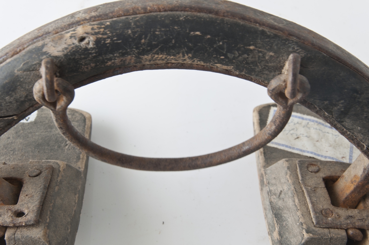 Form: Ytterst i kantene under er det en ring av jern til å tre tømmene igjennom. Litt nærmere midten er det en "treklamp" som presses mot ryggen til hesten. En "hank" av jern på midten. "Treklampene er festet med jern til bøylen.
