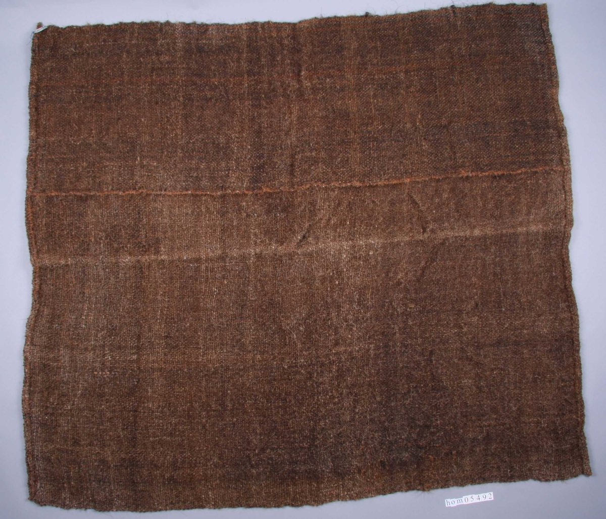 Rektangulær silduk laga av hår frå kuhalar, spunne og tvinna til tjukke trådar og vevd til duk. Duken vert brukt til å tørke malt til ølbrygging.