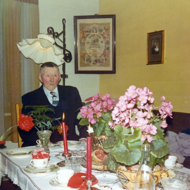 Tomas Fosse (1879 - 1973) ved dekka festbord i stova på 90 årsdagen sin