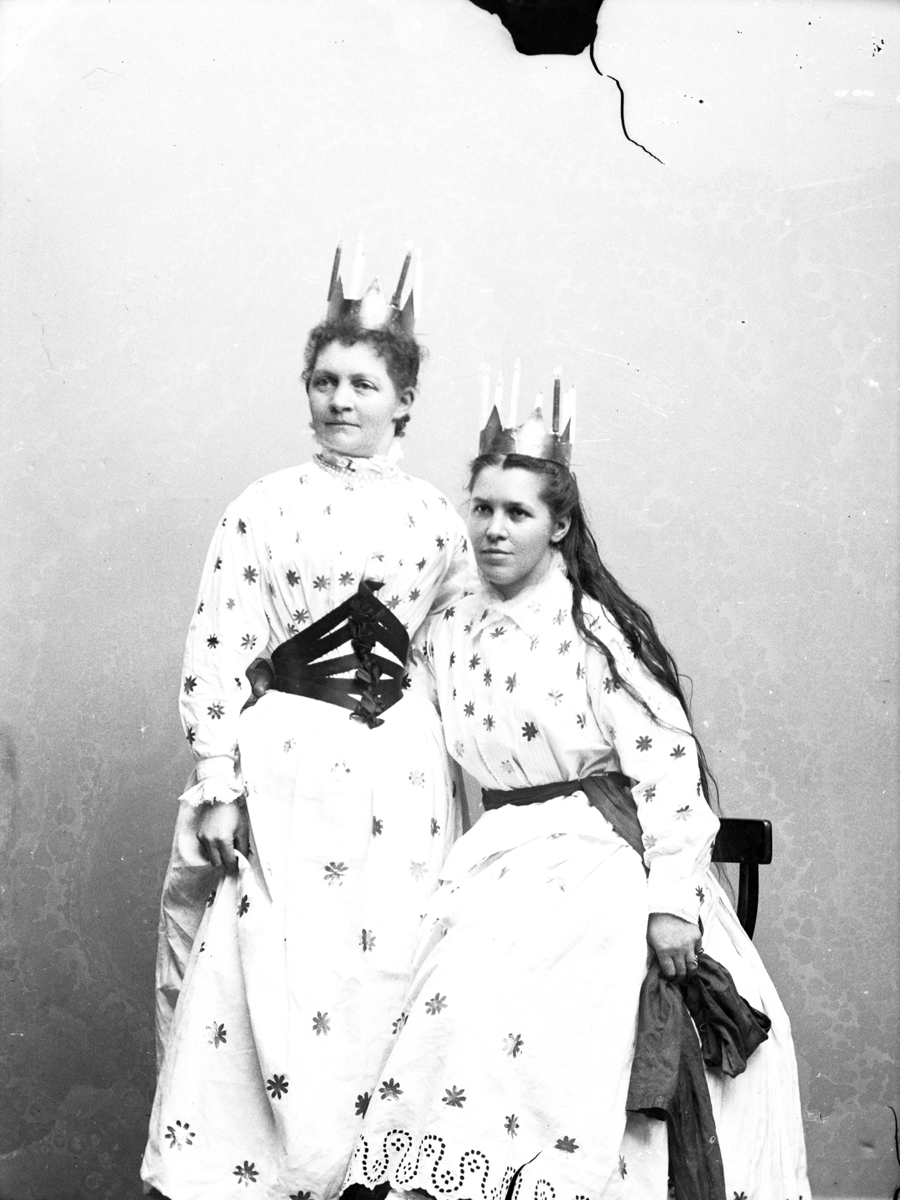 Mathilda Ranch (sittande) och väninnan Hermine Carlsson från Göteborg som Lucior 1897. Mathilda har utslaget år, båda bär kronor av tunn plåt med smala ljus, snarlika stjärnbeströdda klänningar men olika skärp.

Bild 1 är beskuren i nederkant, jämför med Bild 2 där man ser sladden till självutslösaren, som Mathilda håller dold bakom Hermine.
(Negativet har en skada upptill)