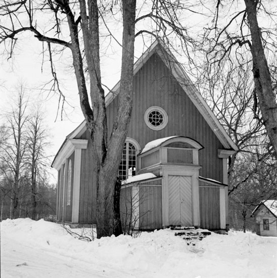 Bystad kyrka (Bysta kyrka) den 23 mars 1937. Kyrkan är gjord av trä och målad i gul färg, och den har en farstu med ett litet originellt utseende. På kyrktomten finns några träd och på marken ligger vit snö.
