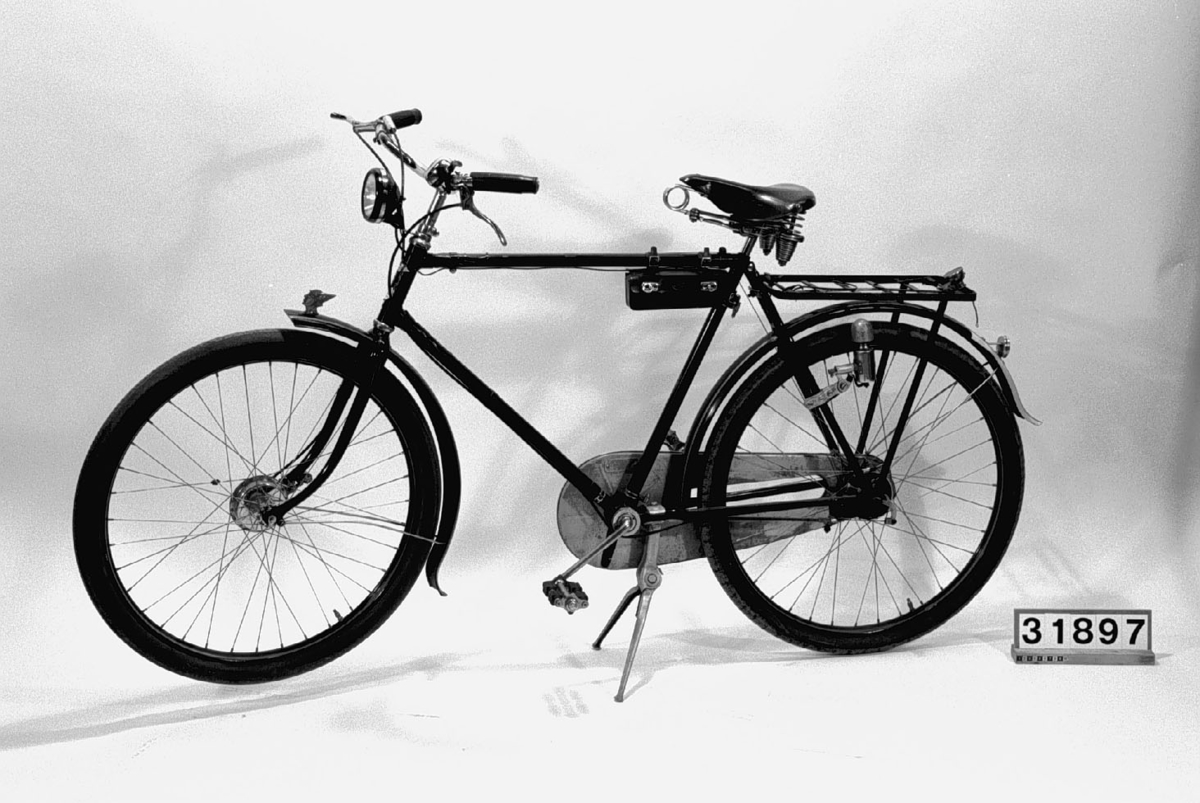 Cykel med vägmätare BT. och tillbehörspakethållare. Sfinx kjedjeskydd i aluminium. F&S (tyskt) framnav och SA (engelskt) baknav märkt: 2 B6.
Tillbehör: Två packväskor av smärting som innehåller en verktygsväska av svart läder, två fasta nycklar, en skruvmejsel, en torkduk, en plåtask för gummirep, märkt: "Romac cycle repair oitfit 4" Junior", en svensk flagga typ vinkel, längd: 320 mm, bredd: 140 mm, en tygpåse, en vit tygpåse, hemgjorda mörkläggningsdetaljer för Hermescykeln, ett till framlyset och ett till baklyset gjorda i papp från andra värdsgrigets tid ( tillhör den Hermes cykel som T Wilner år 1970 överlät till Tekniska Museet), en pappask: reparationsask av svensk tillverkning, en gul tvålask märkt:"Shell" med gul tvål i samt en handduk, vit med röd dekor.