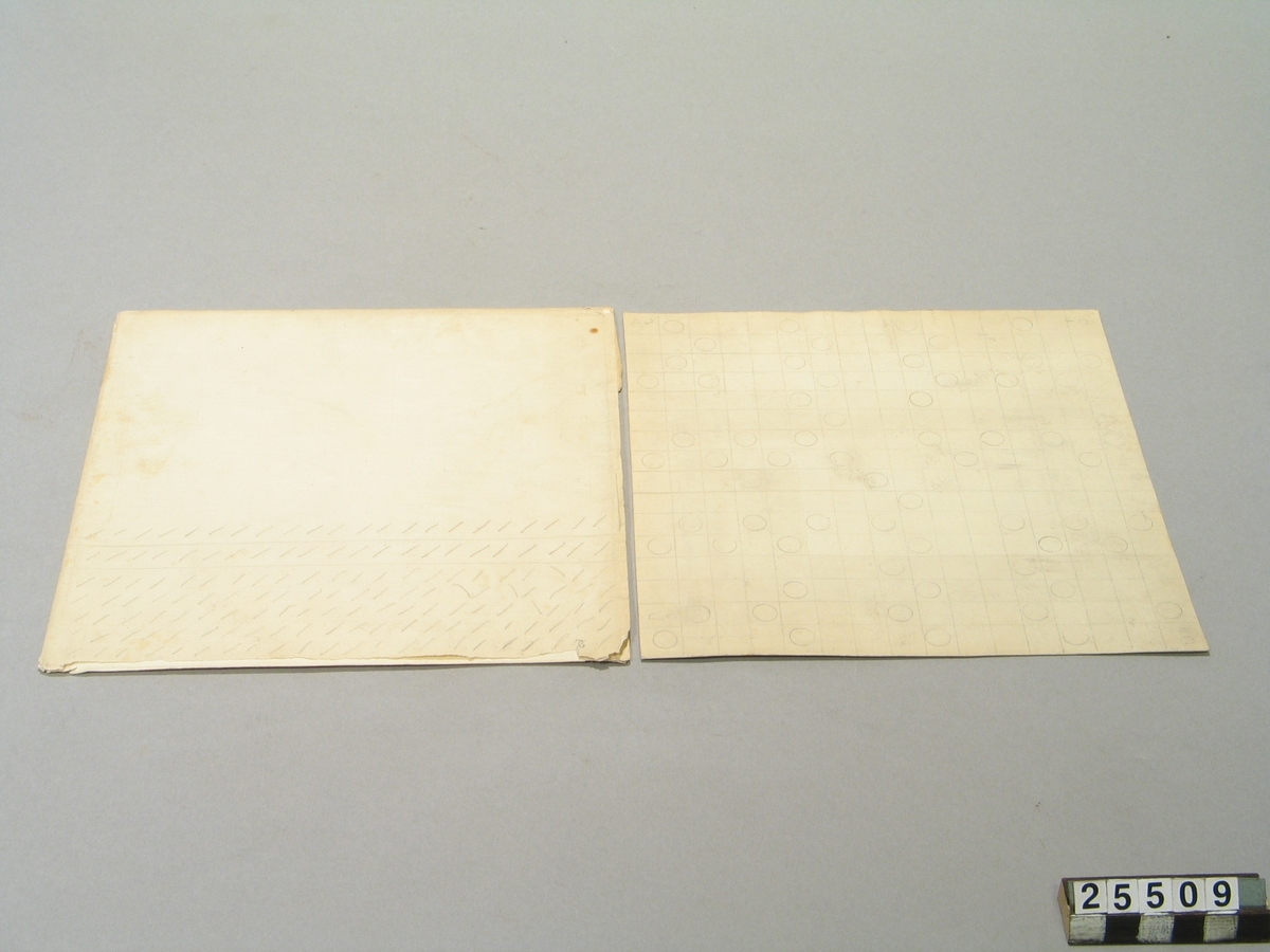 Skiva för skifferskrift, enligt engelsmannen Flamms metod. Av papp med runda ringar. Omslaget med vattenstämpel "Van Gelder Pro Patria".
