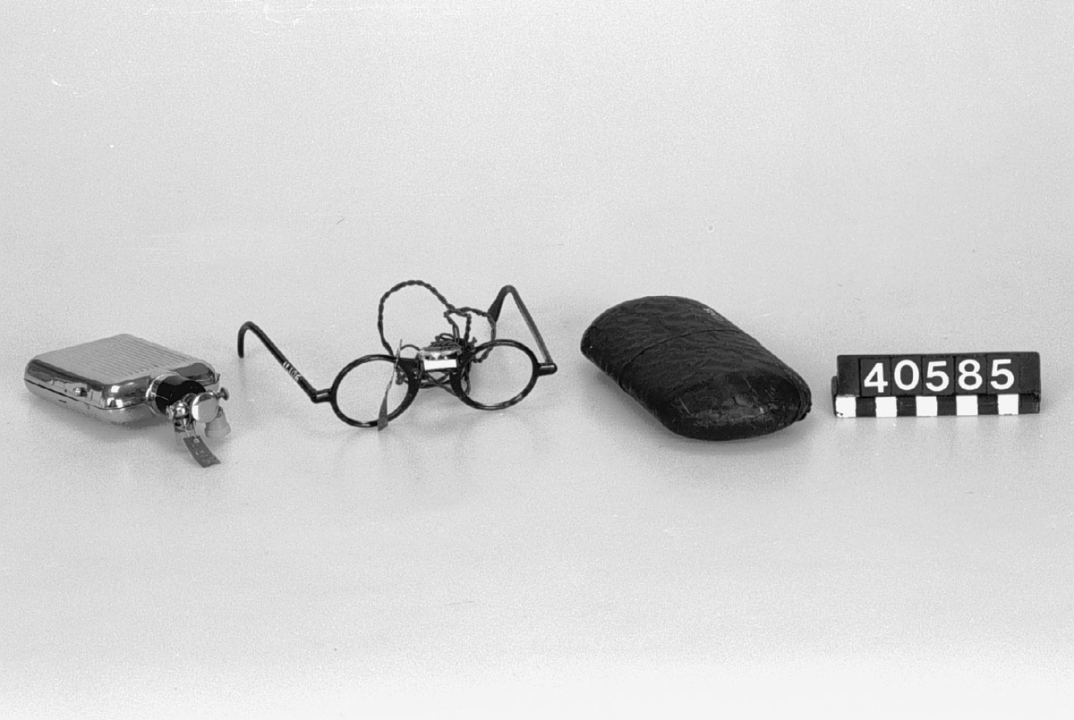 Glasögon med belysning, för läkare i fodral och med batteribehållare av metall.