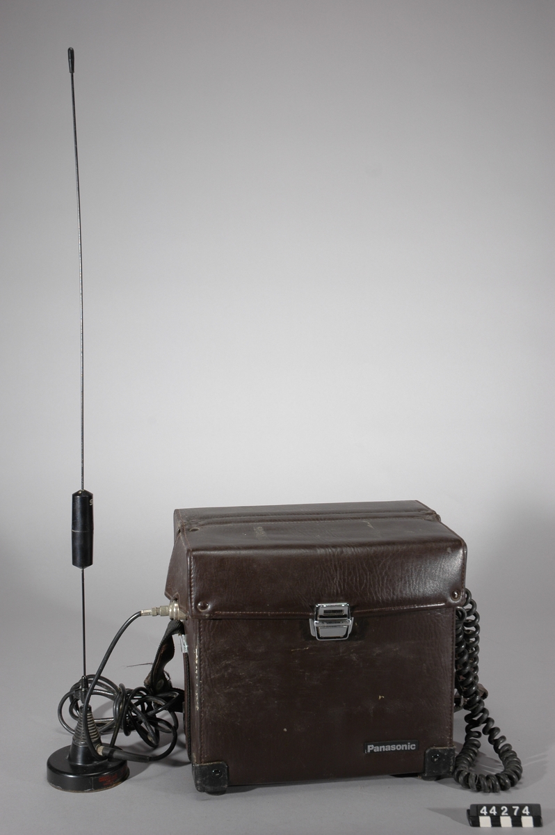 Bärbar NMT 450 mobiltelefon i läderväska, antenn med magnetfotfäste för användning i exempelvis bil.
Tillbehör: Separat antenn samt läderväska.