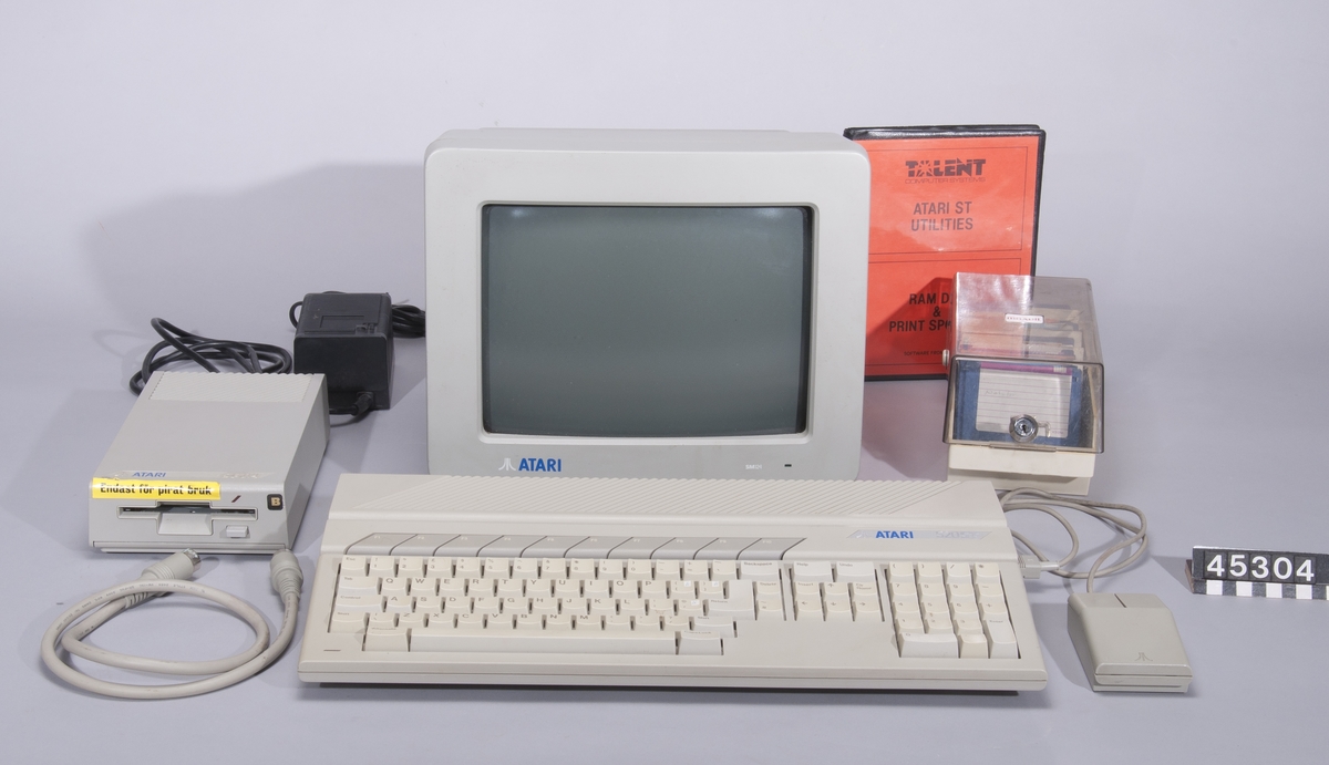 Atari 520 ST  Grått tangentbord med integrerad dator. Processor: Motorola 68000, klockfrekvens 8 MHz. Bussbredd: 32/16 bit 512 KB RAM. Ljudkrets: Yamaha YM2149F Operativsystem Atari TOS  Ser nr A1 1010711 1985  Skärm Atari model SM124 nr N1954467294 tillv maj 1999 i Korera  Mus Atari STMI nr P2855016079  Diskettenhet Atari SF314 ser nr A1645006861 med nätenhet ty PS 32 daterad 2-85  Diskettlåda med 31 disketter, bland annat program (Cubase, Notator, Word) och spel (Lemmings), PC-emulator och DOS, Midi-filer och ljudbibliotek.  Program i förpackning, 2st disketter: Atari ST utilities, RAM disk & Print spooler, tillv Talent Computer Systems, Skottland