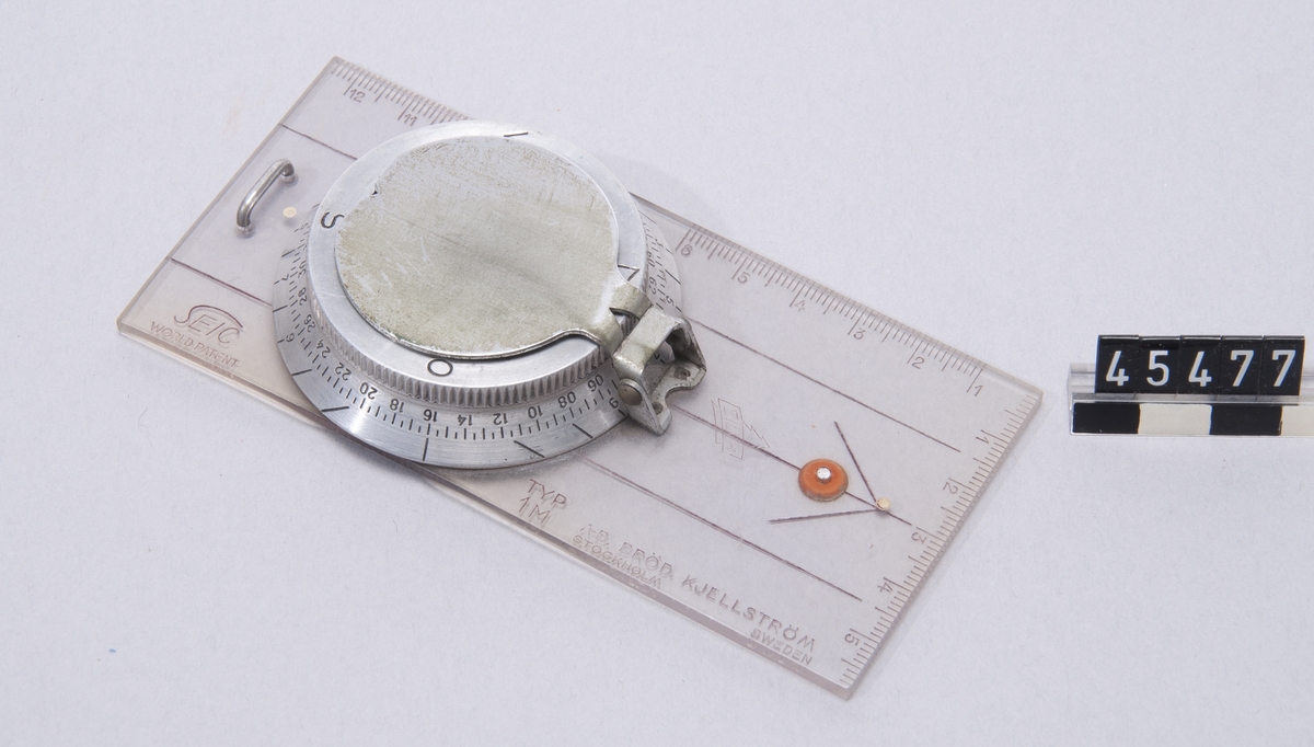 Kompass med syftspegel, linjal graderad i tum och cm. Tillverkare SEIC, märkt "World patent". 6400 graders indelning.