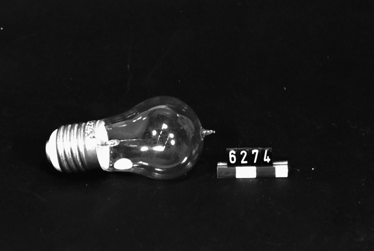 Elektrisk koltrådslampa med normalfattning, klotform, 110 volt, tre normalljus. Fattningen märkt: "99/VIII". På lampan etikett: "110/3".