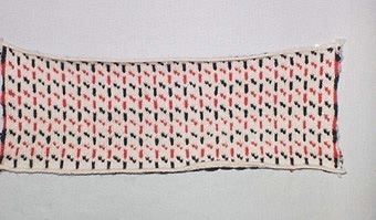 Stickprov i 3-trådigt ullgarn,
mönster "Jyske" i blått och rött på naturvit botten.