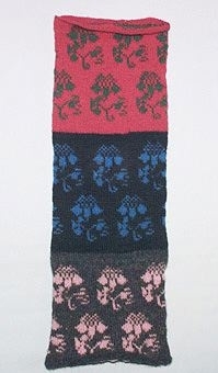 Stickprov i 2-trådigt ullgarn. Mönstret "Nejlikan" i tre olika färgkombinationer, röd/grön, svart/blå och natursvart/rosa.