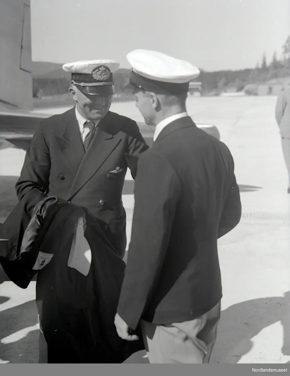 Åpningen av Fornebu flyplass 01.06.1939.
Litt av halepartiet på et fly. 2 personer i uniform.