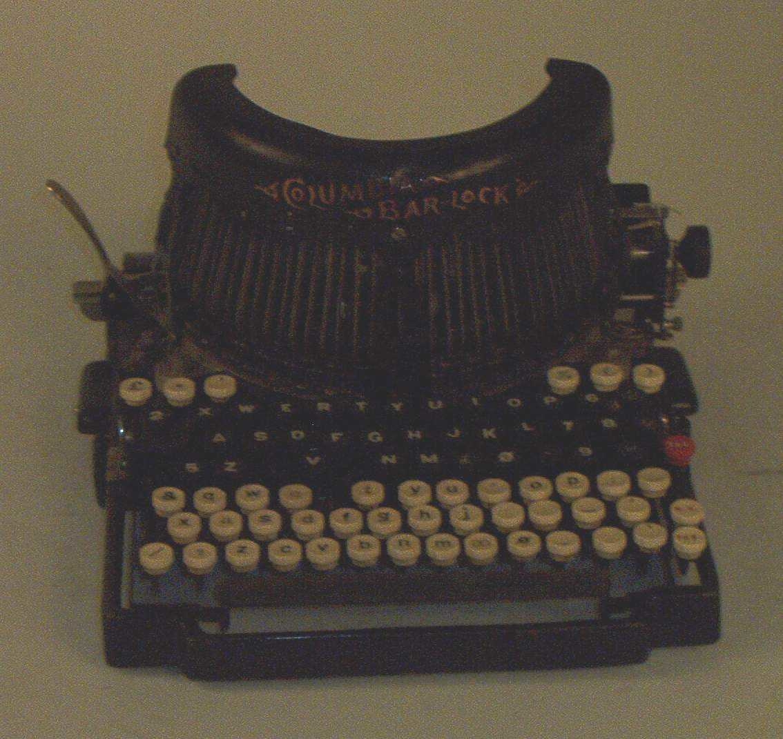 Skrivemaskinen med dobbelt tastatur, ett for store bokstaver og ett for små. Det ene tastaturen er hvitt, det andre svart.
