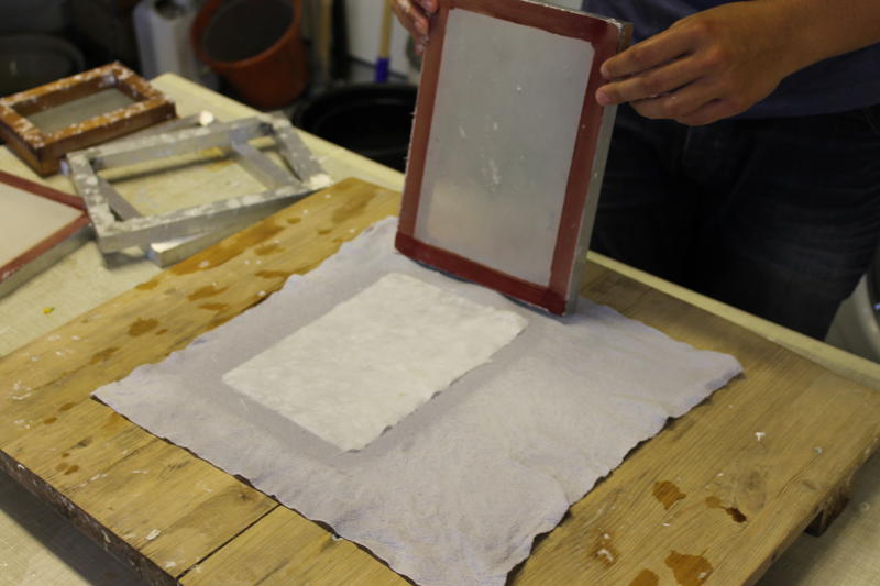 The form is lifted up and the paper is placed to dry on a rag